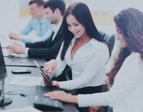 office workers with a tablet in front of the computer, discussin