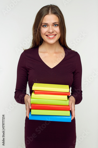 Student girl holding ppile of books.