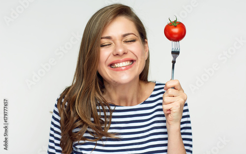 Happy woman holding fork with tomato.