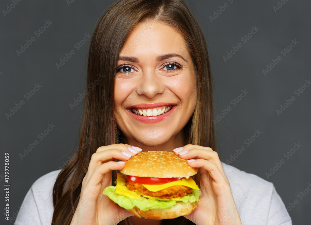 Smiling girl holding big burger.