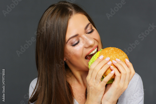 Woman eating big burger with fun.