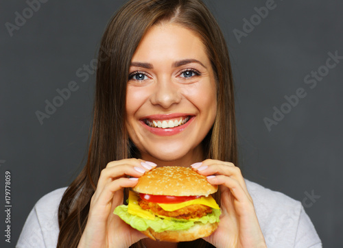 Smiling girl holding big burger.
