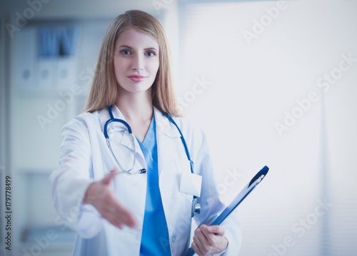 Doctor woman is standing in the near window photo