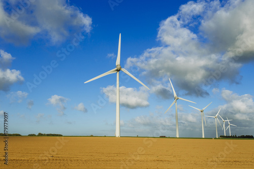 Wind turbines of a power plant for electricity generation in Normandy, France. Concept of renewable sources of energy. Agricultural fields. Environmentally friendly electricity production. Toned