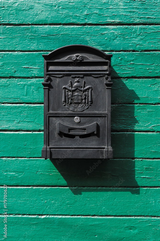 black mailbox on a green wooden boards black mailbox on a green wooden boards