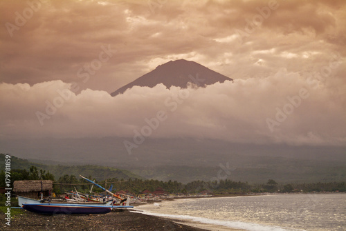 Mt. Agung and the Village of Amed. The small fishing village of Amed sits at the base of the active volcano Gunung Agung. Mt. Agung last erupted in 1963 and killed over 1100 people.  photo