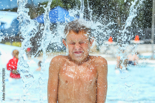 Boy at waterpark being hit with icy cold water photo