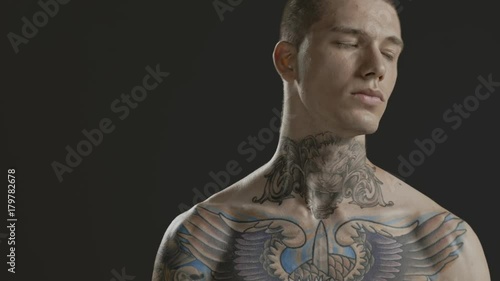 Handsome sexy young man stylish with tattoo on his neck, torso and hand - middle shot portrait studio - Prores - cinematic fashion lighting