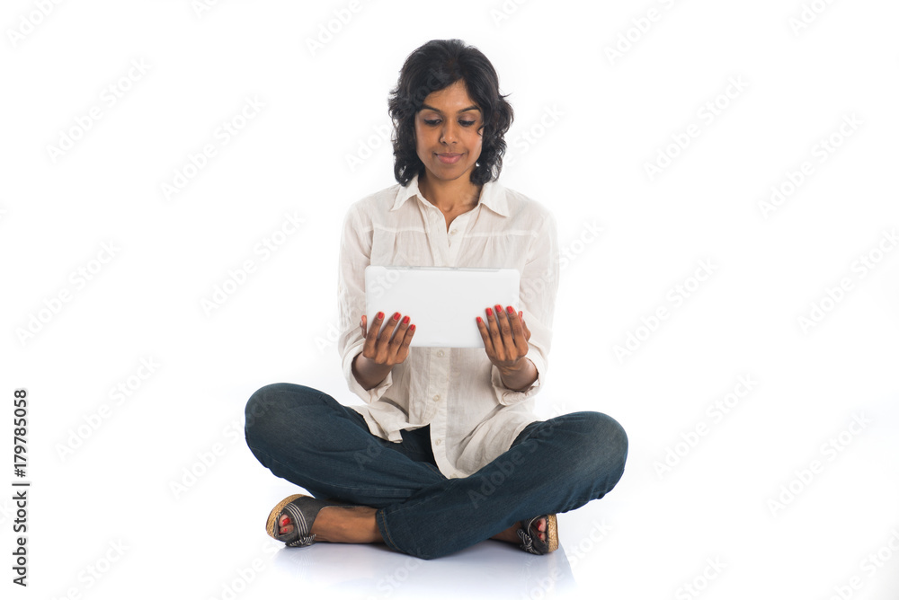 casual indian female using tablet computer casual indian female using tablet computer