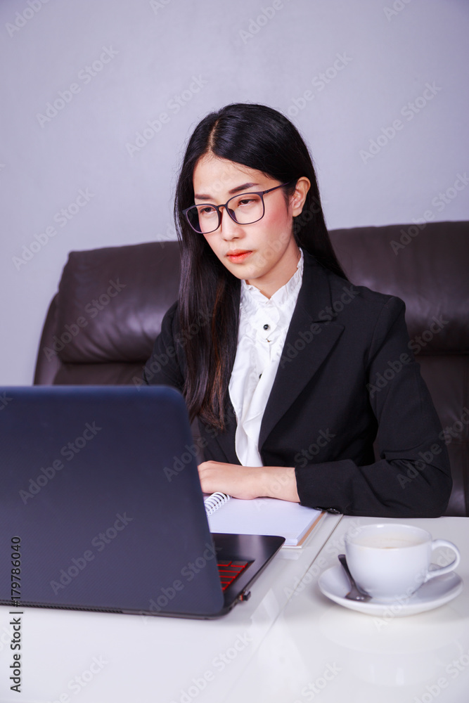 business woman sitting at the desk and using laptop computer for her work