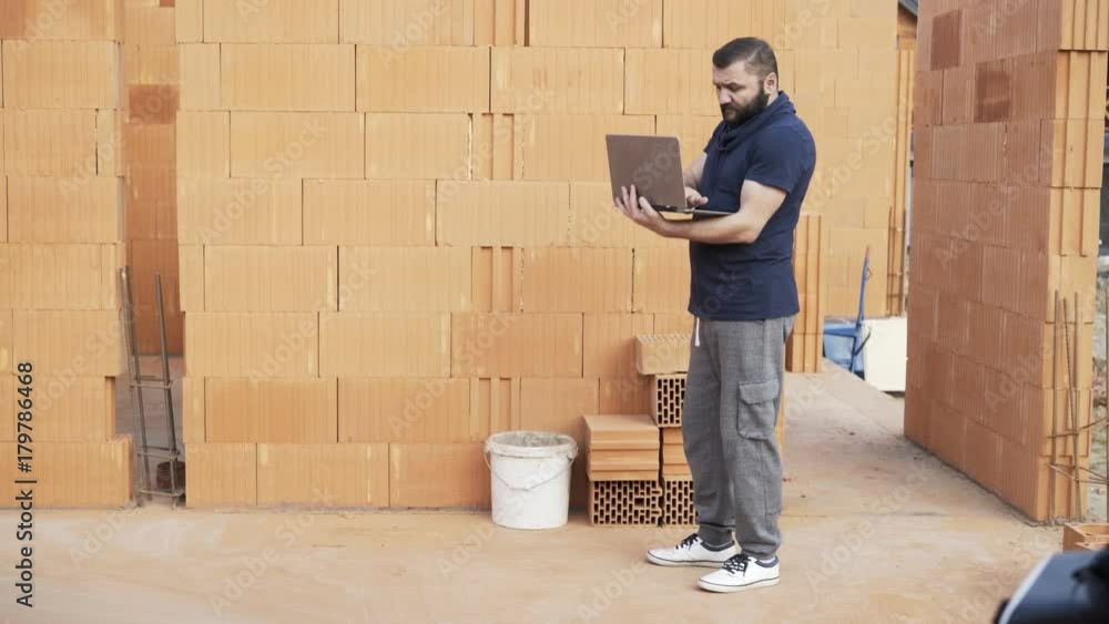 Young male constructor working on laptop at construction site
Young male constructor working on laptop at construction site