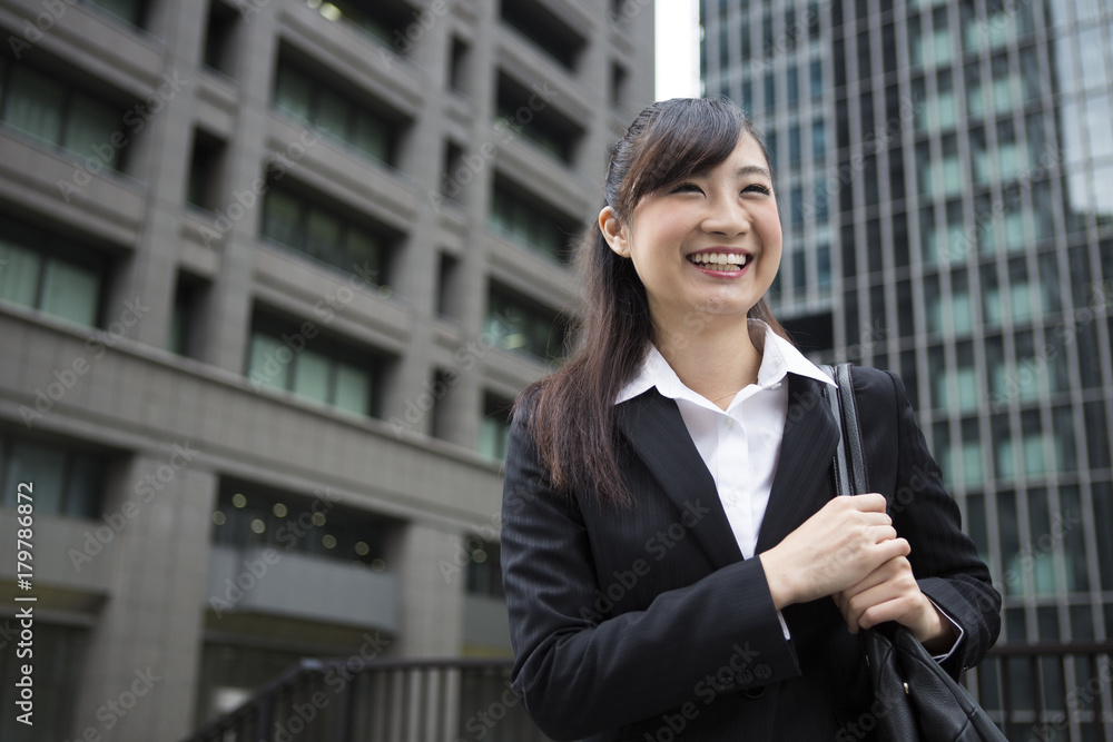 オフィス街で立ち止まる女性 オフィス街で立ち止まる女性