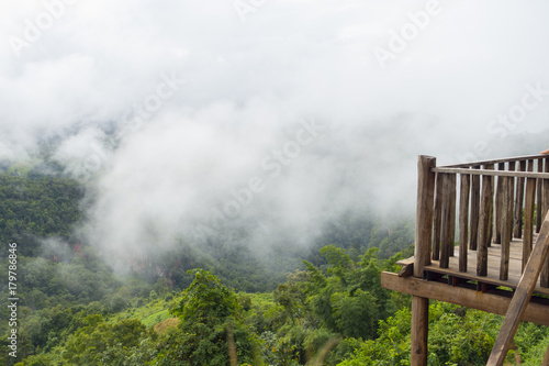 Wood terrace with view on mountain hills and mist