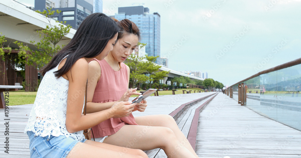 Friends talking at outdoor with cellphone