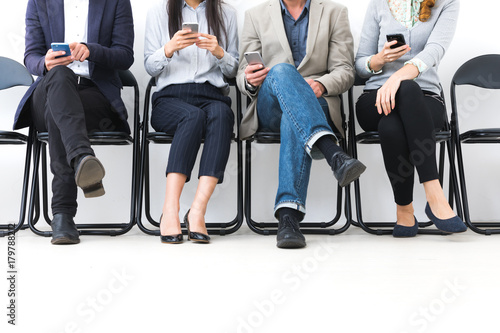 Sitting men and women using smart phone.