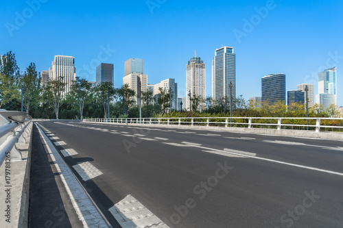road through the bridge with city skyline background © hallojulie