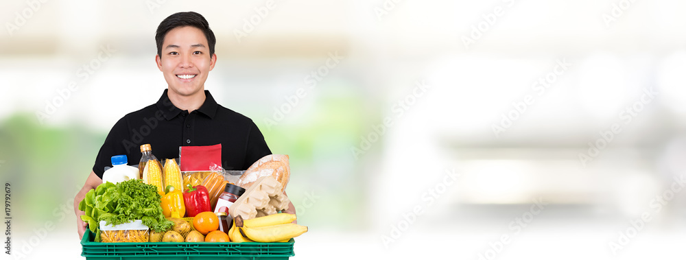 Grocery store Asian delivery man holding food basket on blur white banner  background Photos | Adobe Stock