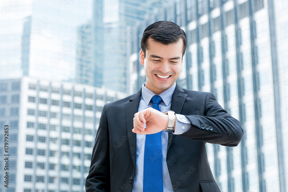Φωτογραφία Businessman smiling and looking at his wristwatch with a happy moment in the cit