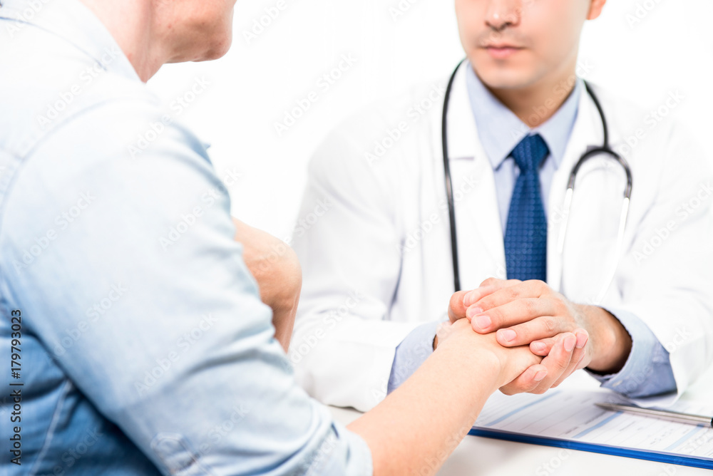 Doctor comforting a senior female patient by holding her hand Doctor comforting a senior female patient by holding her hand