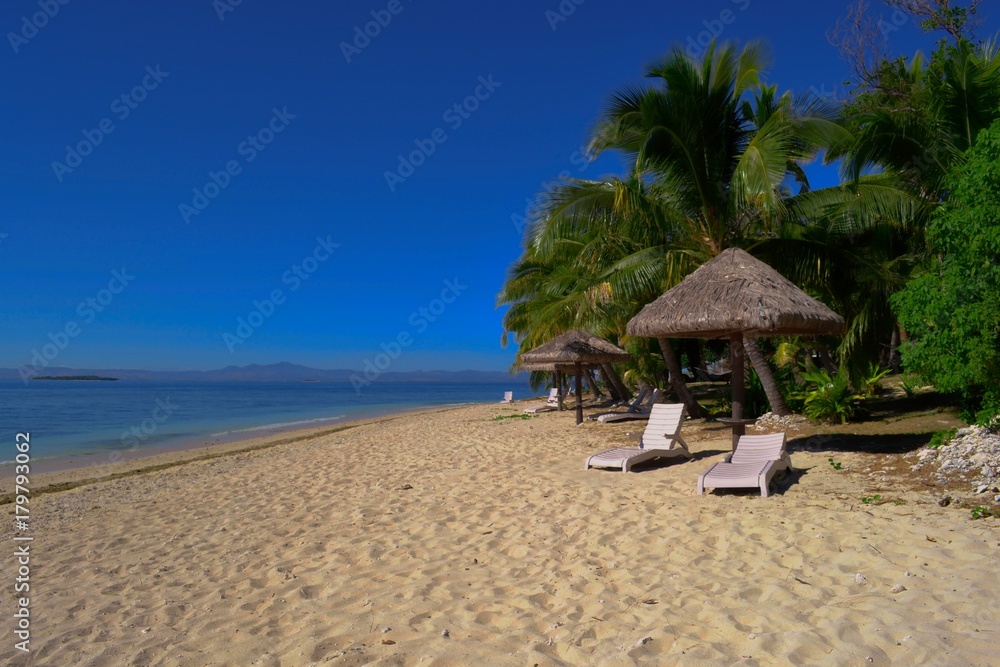 Tropical beach on an island with chairs and umbrellas for relaxation 