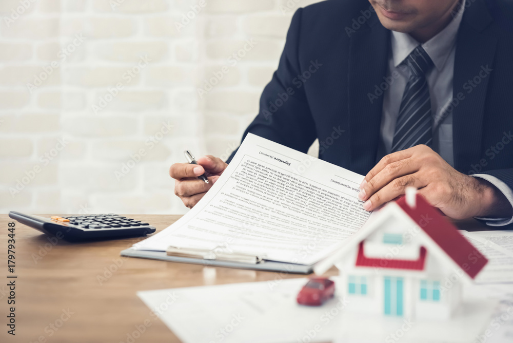 Φωτογραφία Businessman as a real estate agent reviewing contract before signing