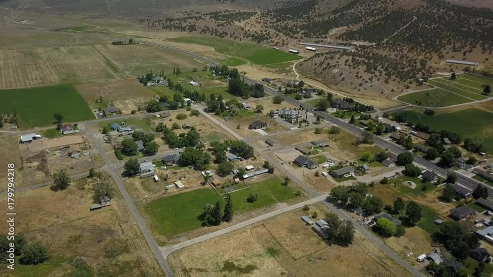 Aerial rural city community homes fields and mountain. Aerial rural farming community agricultural economy. Spring summer weather mountain valley green agriculture field. Aerial rural city community homes fields and mountain. Aerial rural farming community agricultural economy. Spring summer weather mountain valley green agriculture field.