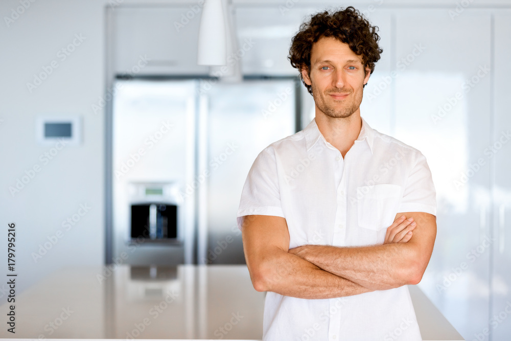 Portrait of a smart young man standing in kitchen Portrait of a smart young man standing in kitchen