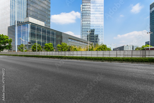 empty asphalt road front of modern buildings under blue sky