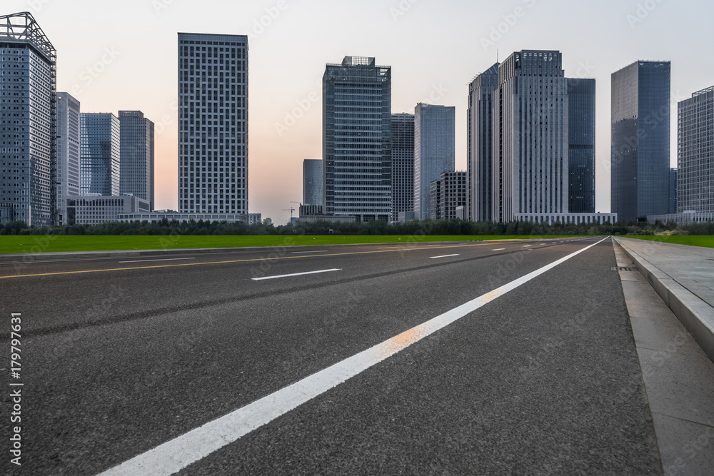 clean asphalt road through modern city skyline