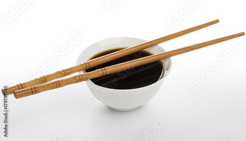 Soy sauce and chopsticks isolated on white background