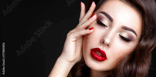 Beautiful woman portrait. Young lady posing close up on black background. Glamour make up  red lipstick  red nails. 