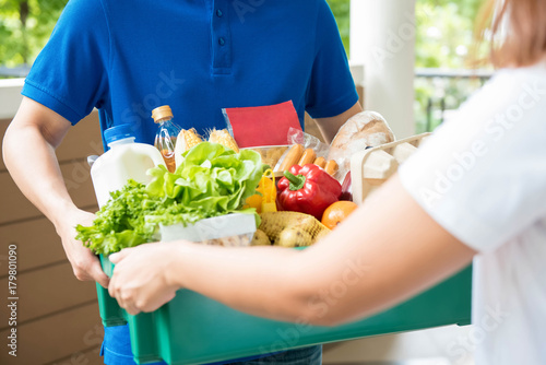 Photos Agrocery delivery man delievering food to a woman at home