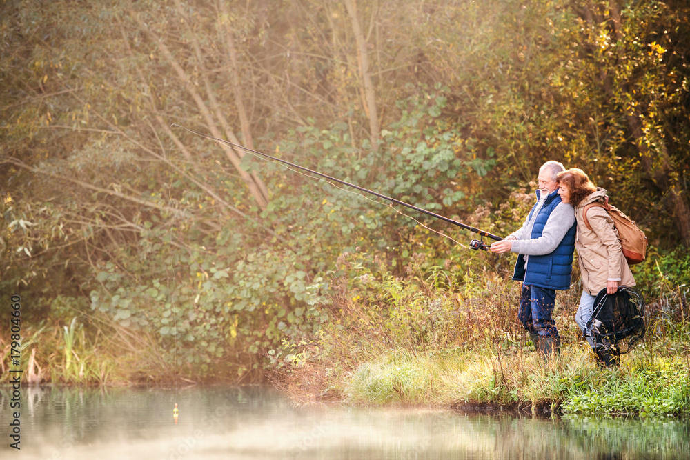 Senior couple fishing at the lake in autumn. Senior couple fishing at the lake in autumn.