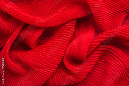 Embossed fabric, pleated. Red material textile.