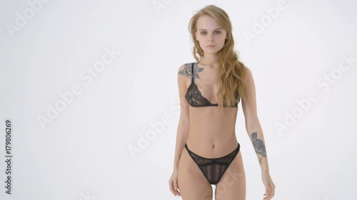 Beautiful young woman in black lingerie on the white background