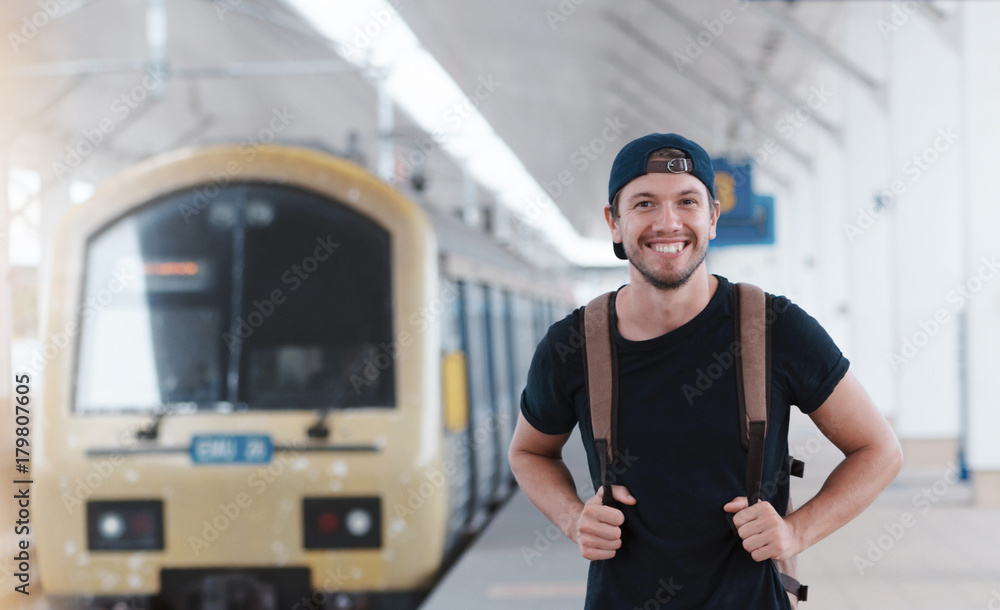 Young traveler walking with backpack on train staition and waiting train Young traveler walking with backpack on train staition and waiting train
