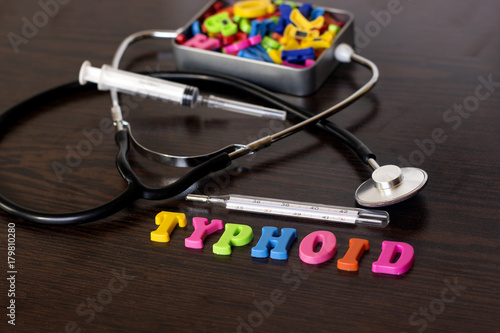 colorful letter typhoid and thermometer,stethoscope,syringe,metal box of letters