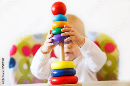 the kid plays the pyramid. child playing with wooden toys