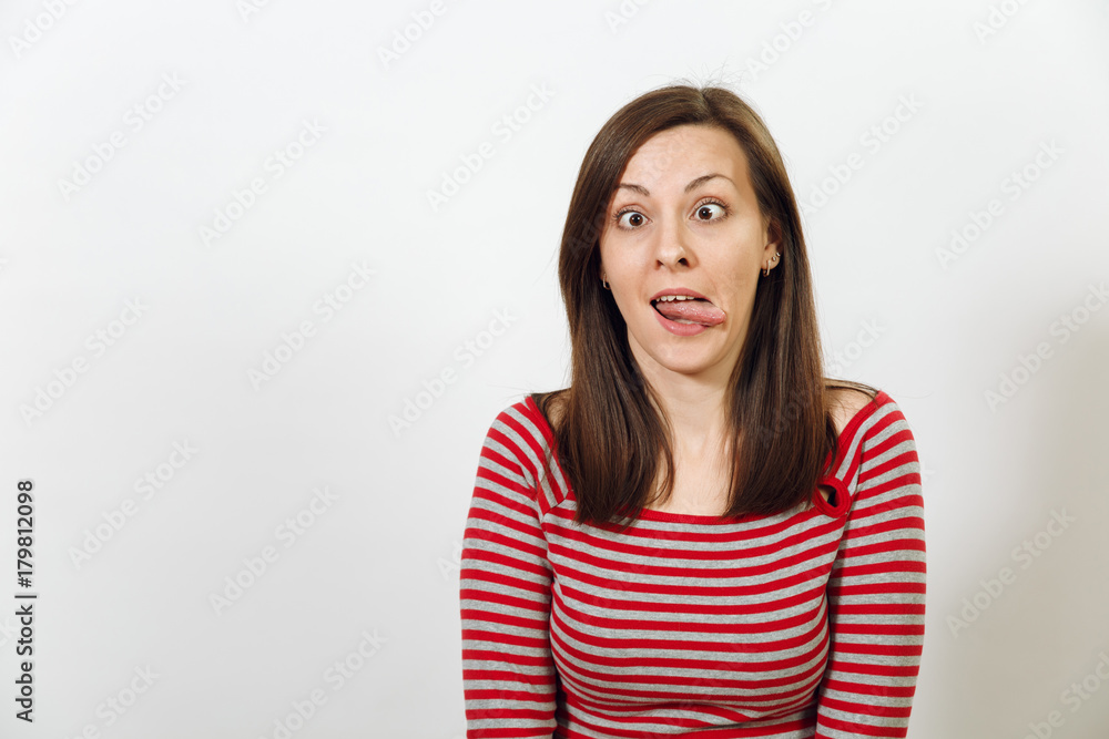 Beautiful European young happy brown-haired woman with healthy clean skin, dressed in casual red and grey clothes, fooling and showing the tongue on a white background. Emotions concept. Beautiful European young happy brown-haired woman with healthy clean skin, dressed in casual red and grey clothes, fooling and showing the tongue on a white background. Emotions concept.