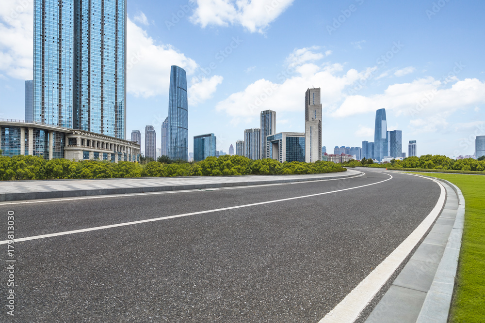 asphalt road through the modern city skyline asphalt road through the modern city skyline