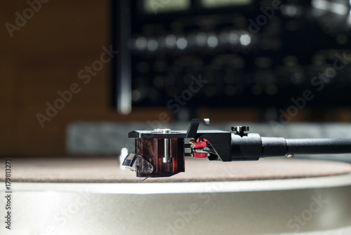 Moving magnet cartridge on the tonearm on a blurred background