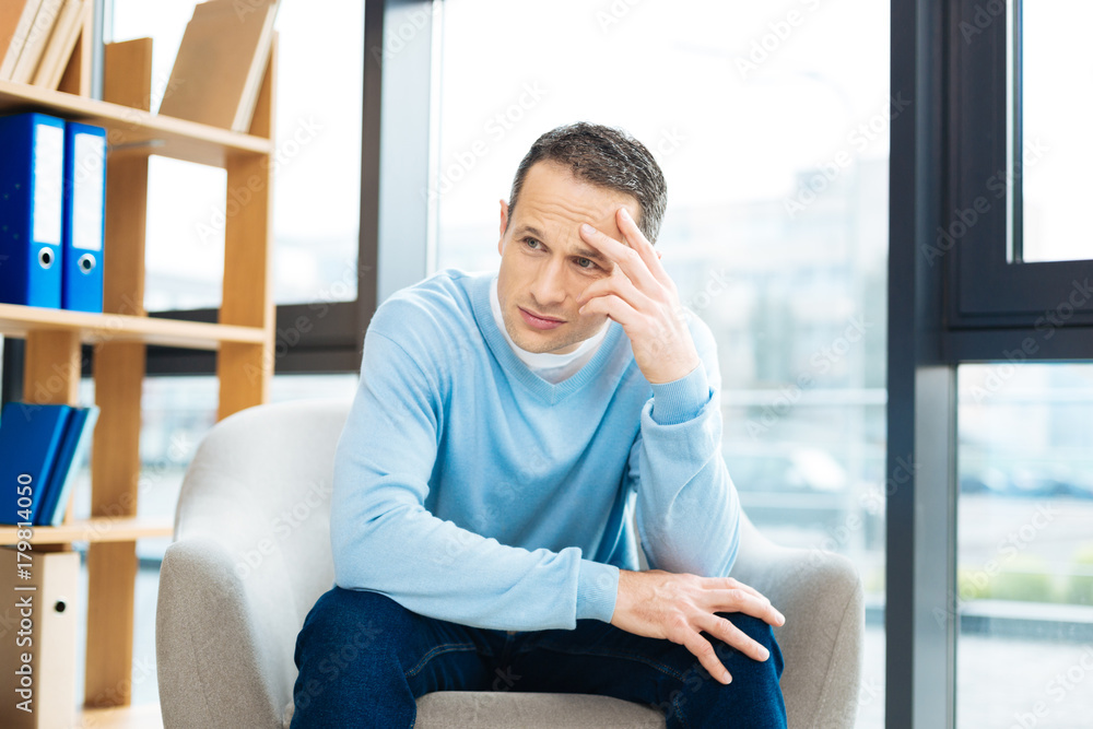 My life. Serious thoughtful cheerless man sitting and holding his head while thinking about his life My life. Serious thoughtful cheerless man sitting and holding his head while thinking about his life