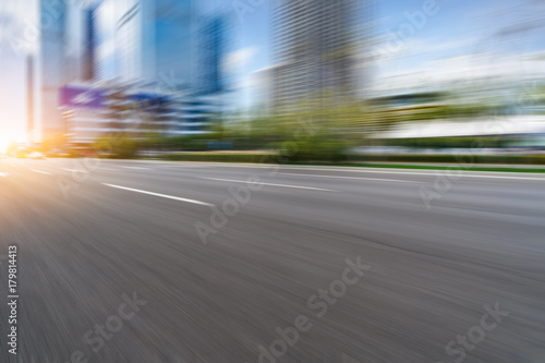 blurred empty urban road and modern buildings under blue sky