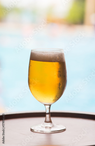 glass of craft beer with pool background