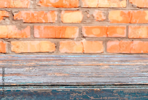 Old wooden table on the background of a brick wall