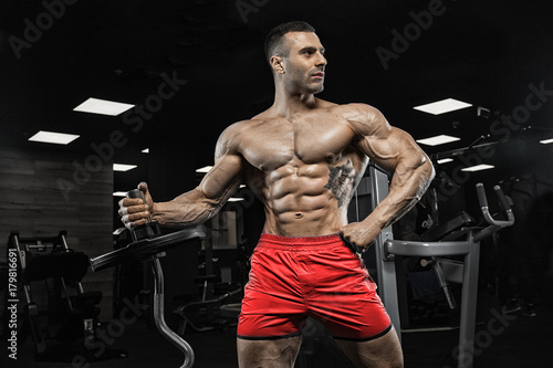 man in gym. Muscular bodybuilder guy doing exercises with barbell. Strong person. Sports background. Young athlete ready for weight lifting training.