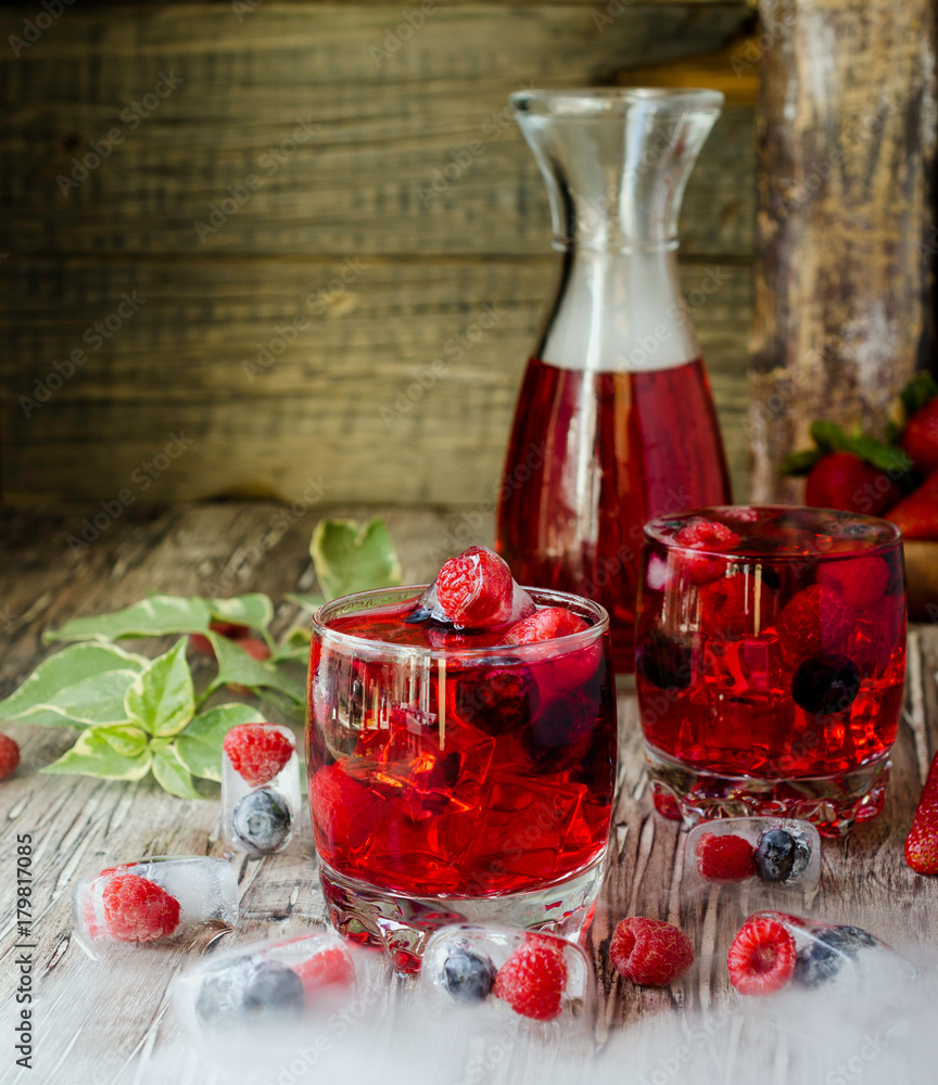 Summer berry lemonade with frozen berries on a wooden rustic table, selective focus Summer berry lemonade with frozen berries on a wooden rustic table, selective focus