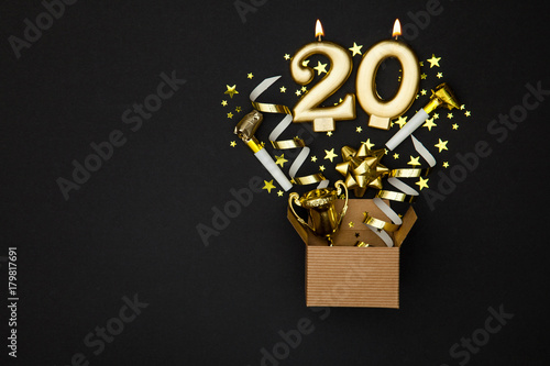 Number 20 gold celebration candle and gift box background