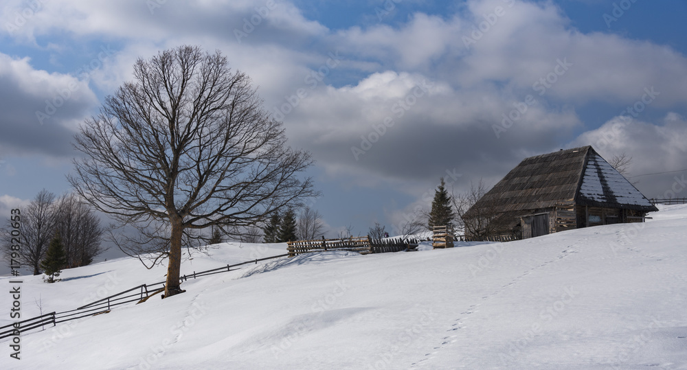 Winter landscape with wooden house high in mountains