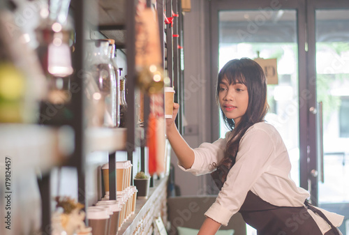Asian women Barista is decorating a coffee shop.